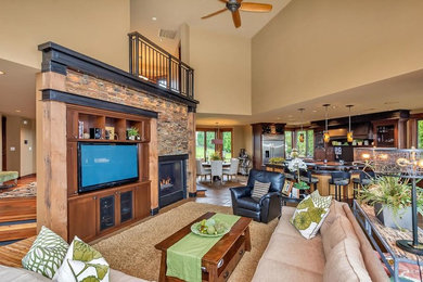 Example of a large trendy open concept concrete floor family room design in Seattle with beige walls, a standard fireplace, a stone fireplace and a media wall