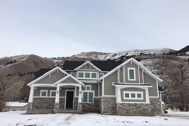 Large craftsman gray two-story glass exterior home idea in Other