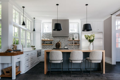 Inspiration for a large transitional l-shaped dark wood floor, gray floor and tray ceiling eat-in kitchen remodel in Chicago with shaker cabinets, white cabinets, quartzite countertops, multicolored backsplash, cement tile backsplash, stainless steel appliances, an island, white countertops and a farmhouse sink
