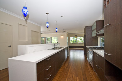 Inspiration for a large modern single-wall eat-in kitchen in Brisbane with a double-bowl sink, flat-panel cabinets, dark wood cabinets, granite benchtops, window splashback, stainless steel appliances, medium hardwood floors and with island.