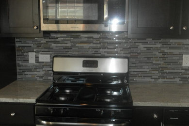 Transitional kitchen photo in Chicago with dark wood cabinets, granite countertops, multicolored backsplash, matchstick tile backsplash and stainless steel appliances