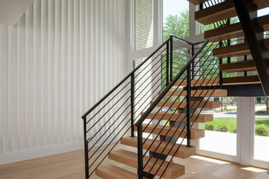 Inspiration for a large contemporary wooden floating open and metal railing staircase remodel in Charlotte