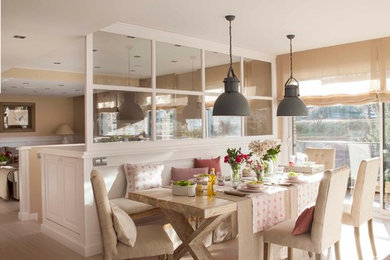 Photo of a mid-sized country open plan dining in Madrid with beige walls, light hardwood floors and beige floor.