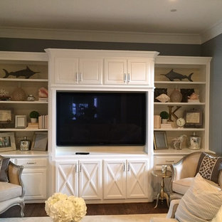 This is an example of a small traditional enclosed family room in Dallas with a library, grey walls, medium hardwood floors, no fireplace and a built-in media wall.