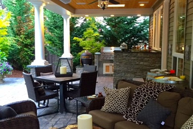 Mid-sized transitional backyard stamped concrete patio photo in Seattle with a fire pit and a roof extension