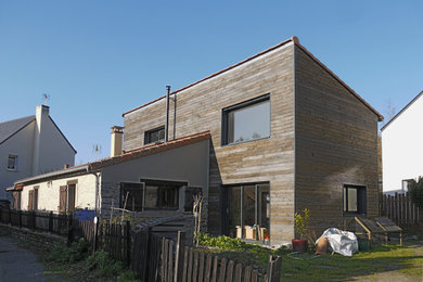 Aménagement d'une grande façade de maison beige contemporaine en bois et bardage à clin à un étage avec un toit en appentis, un toit en tuile et un toit rouge.
