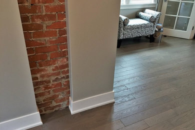 Hallway - contemporary medium tone wood floor hallway idea in Calgary with beige walls