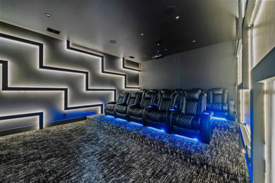 Example of a trendy carpeted home theater design in Orlando with gray walls