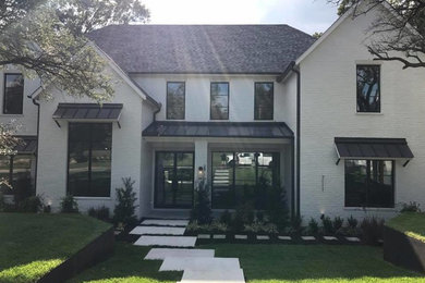 Large transitional two-storey brick white house exterior in Dallas.