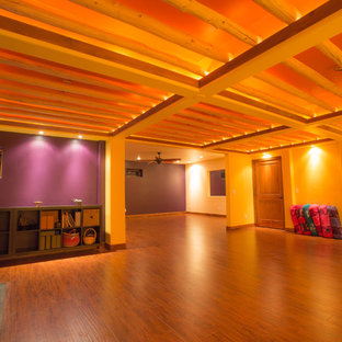 デンバーの大きいラスティックスタイルのおしゃれなヨガスタジオ (紫の壁、無垢フローリング、茶色い床) の写真