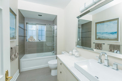 Mid-sized trendy master brown tile and porcelain tile porcelain tile and brown floor bathroom photo in Toronto with flat-panel cabinets, white cabinets, a one-piece toilet, beige walls, a vessel sink, quartz countertops and white countertops