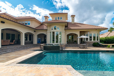 Large tuscan backyard stone and rectangular pool fountain photo in New Orleans