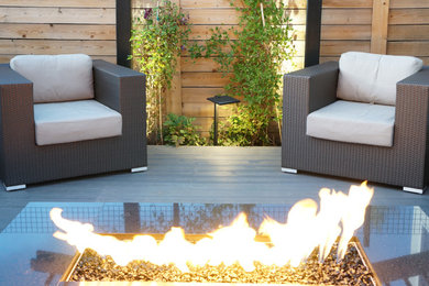 Example of a small trendy backyard deck design in Denver with a fire pit and no cover