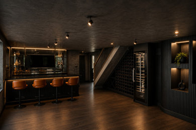 Photo of a large contemporary games room in Kent with black walls, dark hardwood flooring, a built-in media unit and brown floors.