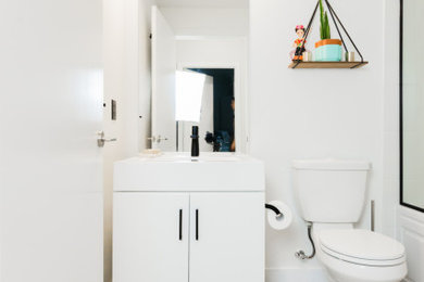 Mid-sized 3/4 porcelain tile, gray floor and single-sink toilet room photo in Toronto with flat-panel cabinets, white cabinets, white walls, solid surface countertops, white countertops and a freestanding vanity