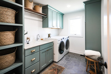 Inspiration for a mid-sized transitional single-wall ceramic tile and gray floor dedicated laundry room remodel in Chicago with an undermount sink, shaker cabinets, blue cabinets, quartzite countertops, white backsplash, subway tile backsplash, white walls, a side-by-side washer/dryer and white countertops