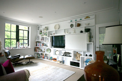 Modelo de salón para visitas abierto actual grande con paredes blancas, moqueta, pared multimedia y suelo beige