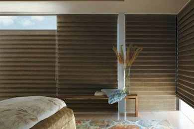 Guest medium tone wood floor bedroom photo in Phoenix with beige walls and no fireplace
