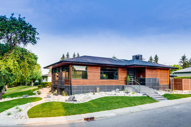 Photo of a mid-sized contemporary partial sun front yard gravel landscaping in Calgary.