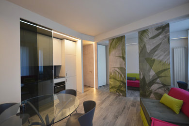 Foto de salón abierto actual pequeño con paredes grises, suelo de baldosas de porcelana, televisor colgado en la pared, suelo gris y papel pintado
