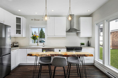 Example of a mountain style laminate floor and brown floor kitchen/dining room combo design in Vancouver with gray walls and a corner fireplace