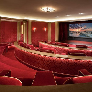 Inspiration for a large victorian enclosed home cinema in Orange County with red walls, carpet, a projector screen and red floors.