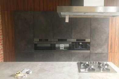 На фото: прямая кухня в стиле лофт с обеденным столом, серыми фасадами и островом с