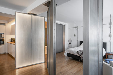 Foto de dormitorio tipo loft y blanco y madera urbano grande con paredes blancas y suelo de madera en tonos medios