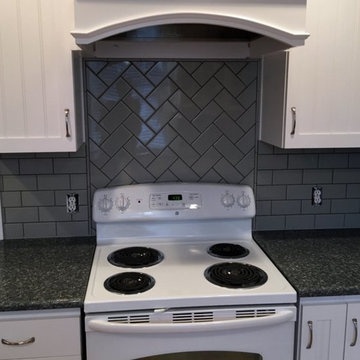 Kitchen with Gray tile backsplash and White Beadboard Cabinets