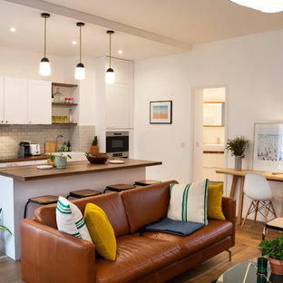 パリのコンテンポラリースタイルのおしゃれなホームバー (一体型シンク、白いキャビネット、木材カウンター、グレーのキッチンパネル、テラコッタタイルのキッチンパネル、セラミックタイルの床、グレーの床、茶色いキッチンカウンター) の写真