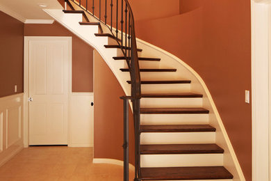 Staircase - mid-sized traditional wooden curved staircase idea in Los Angeles with wooden risers