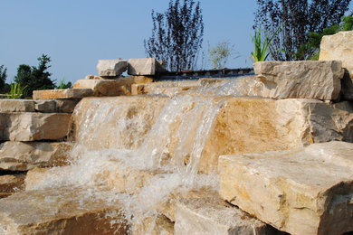 Expansive traditional front yard garden in Grand Rapids with a water feature.