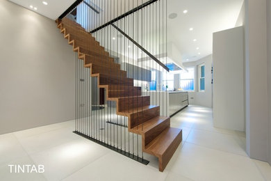 Foto de escalera suspendida minimalista de tamaño medio con escalones de madera y contrahuellas de madera