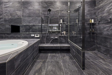 Modelo de cuarto de baño gris y gris y negro minimalista con baldosas y/o azulejos negros, baldosas y/o azulejos de porcelana, paredes negras, suelo de baldosas de porcelana, suelo negro y bandeja