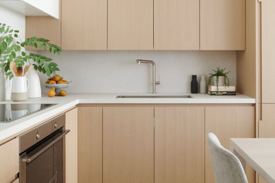 Inspiration for a small modern l-shaped light wood floor eat-in kitchen remodel in Toronto with an undermount sink, flat-panel cabinets, light wood cabinets, quartzite countertops, white backsplash, quartz backsplash, stainless steel appliances and white countertops