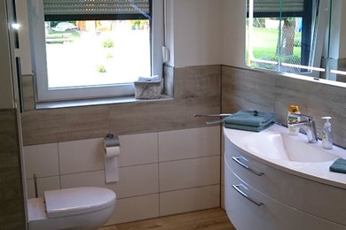 Mittelgroßes Modernes Duschbad mit flächenbündigen Schrankfronten, weißen Schränken, bodengleicher Dusche, beigen Fliesen, Keramikfliesen, weißer Wandfarbe, Keramikboden, Einbauwaschbecken, Mineralwerkstoff-Waschtisch, beigem Boden, weißer Waschtischplatte und Wandtoilette in Berlin