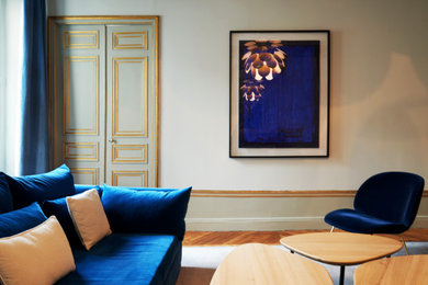 Exemple d'une salle de séjour tendance fermée avec un mur blanc, parquet clair, une cheminée standard et un sol marron.