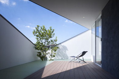 Photo of a mid-sized modern patio in Other with a roof extension.