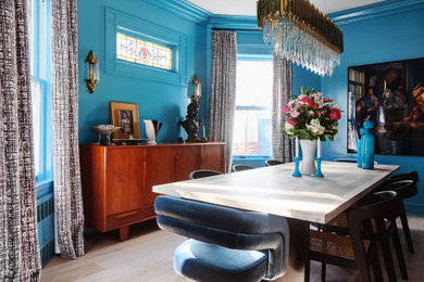 Imagen de comedor retro cerrado con paredes azules, suelo de madera clara y suelo marrón