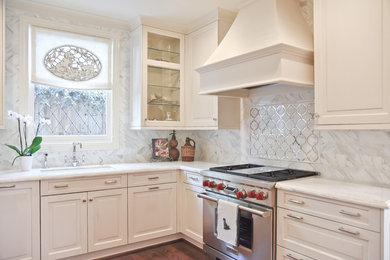 Mid-sized traditional u-shaped separate kitchen in Houston with a drop-in sink, raised-panel cabinets, white cabinets, marble benchtops, white splashback, mirror splashback, stainless steel appliances, dark hardwood floors and no island.