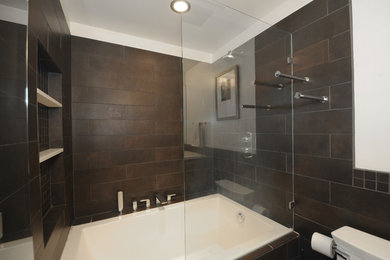 Modelo de cuarto de baño contemporáneo de tamaño medio con puertas de armario de madera en tonos medios, bañera encastrada, combinación de ducha y bañera, baldosas y/o azulejos negros, paredes blancas, lavabo bajoencimera, suelo negro y ducha abierta