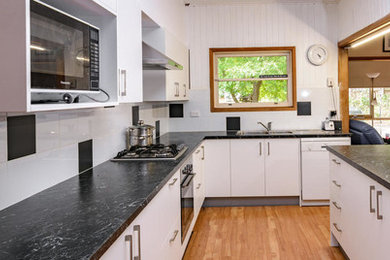 This is an example of a mid-sized modern l-shaped open plan kitchen in Melbourne with with island.