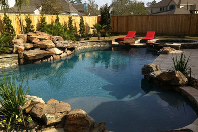 Example of a mid-sized classic backyard tile and custom-shaped lap pool fountain design in Houston