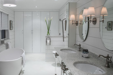 Design ideas for a mid-sized country master bathroom with flat-panel cabinets, white cabinets, a freestanding tub, a wall-mount toilet, white walls, concrete floors, an undermount sink, white floor and terrazzo benchtops.