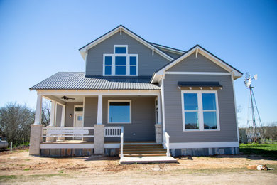 Example of an arts and crafts gray two-story concrete fiberboard exterior home design in Austin with a metal roof