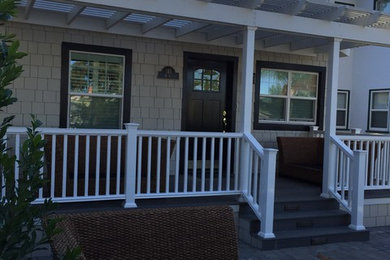 Mid-sized arts and crafts concrete paver front porch idea in San Diego with a pergola