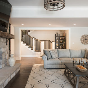 Design ideas for a large classic basement in St Louis with dark hardwood flooring, a standard fireplace, a stone fireplace surround and brown floors.