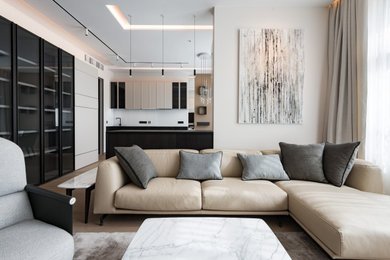 Imagen de salón abierto actual de tamaño medio con paredes beige, suelo de madera clara y suelo beige
