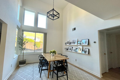 Large mid-century modern light wood floor, beige floor and vaulted ceiling dining room photo in San Francisco