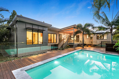 Inspiration for a large modern backyard rectangular aboveground pool in Brisbane with natural stone pavers.